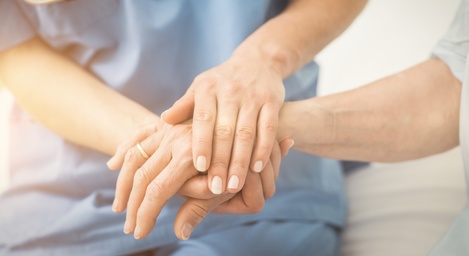 Composite image of nurse holding patient hand 745354